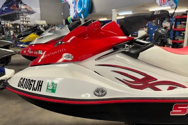 Slide: The Image of 2006 Sea-Doo Wake jet ski in showroom, red and white design, side view. - 3