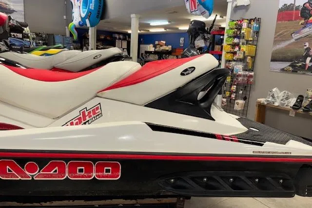 Slide: The Image of 2006 Sea-Doo Wake jet ski with red and white design in a showroom. - 4