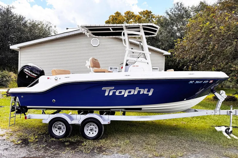 The Image of 2023 Bayliner Trophy T20CC boat on trailer, parked outdoors near a house. - 1