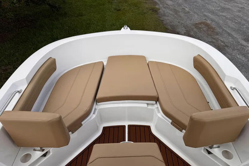Slide: The Image of 2023 Bayliner Trophy T20CC boat with tan cushioned seating and wood-style flooring. - 11