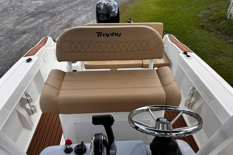 Slide: The Image of 2023 Bayliner Trophy T20CC boat interior with tan seating and steering wheel. - 21