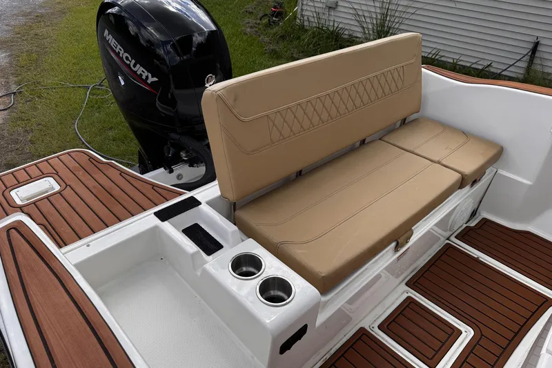 Slide: The Image of 2023 Bayliner Trophy T20CC boat interior with tan seating and Mercury engine. - 23