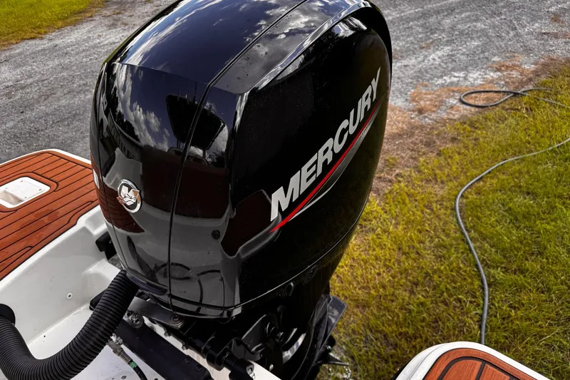 Slide: The Image of Mercury outboard motor on 2023 Bayliner Trophy T20CC boat, parked on grass. - 25