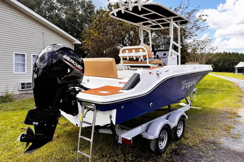 Slide: The Image of 2023 Bayliner Trophy T20CC boat on trailer with Mercury engine, parked near house. - 6