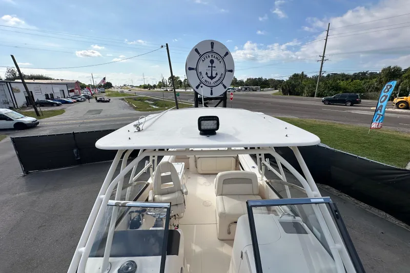 Slide: The Image of 2016 Grady-White Freedom 275 boat on open water, clear sky, American flag displayed. - 113
