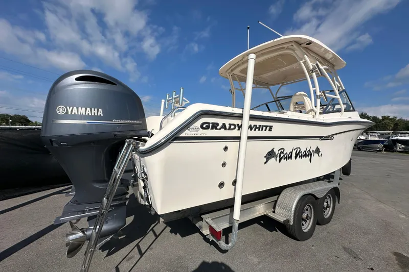 Slide: The Image of 2016 Grady-White Freedom 275 boat on trailer under clear blue sky. - 2