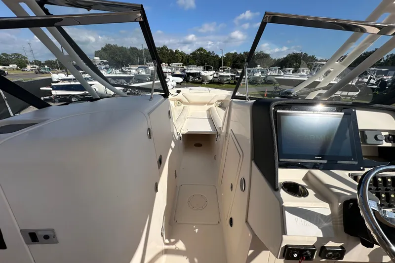 Slide: The Image of 2016 Grady-White Freedom 275 boat cockpit with steering wheel and control panel. - 26