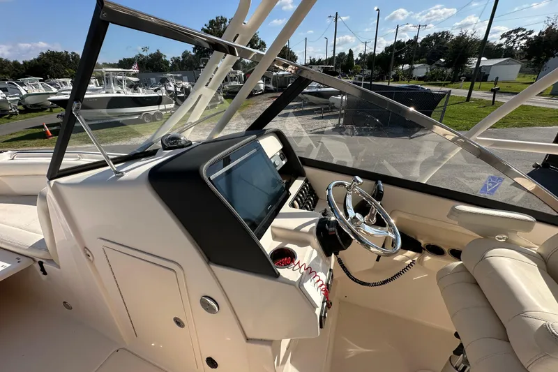 Slide: The Image of 2016 Grady-White Freedom 275 boat helm with steering wheel and control panel. - 27