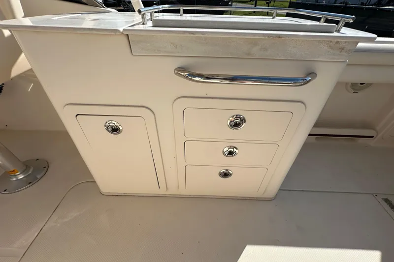 Slide: The Image of Open storage compartment on 2016 Grady-White Freedom 275 boat, featuring cushioned seating. - 50