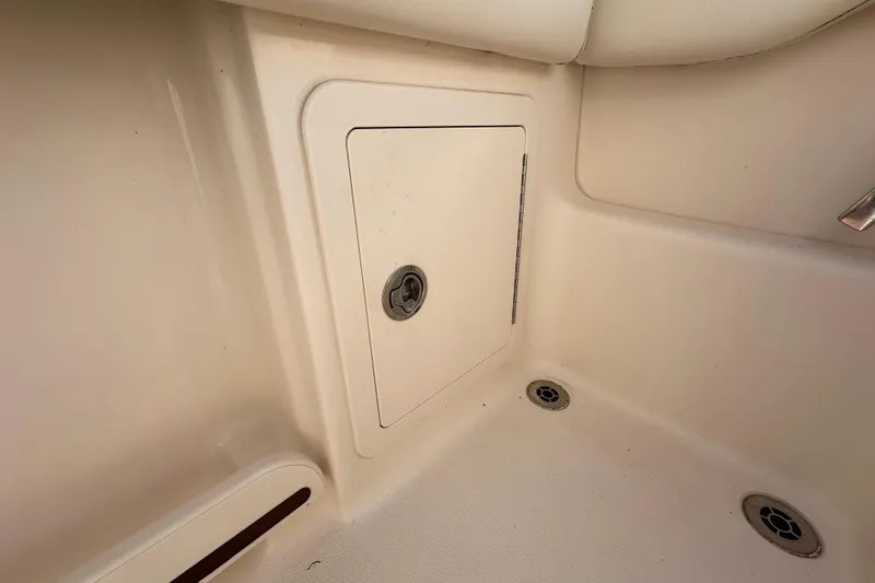 Slide: The Image of 2016 Grady-White Freedom 275 boat interior with seating and windshield, parked outdoors. - 57