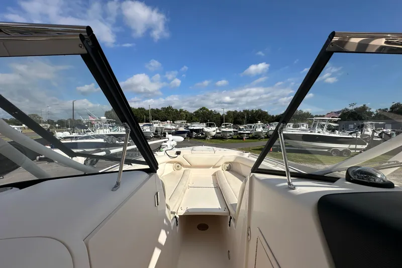 Slide: The Image of 2016 Grady-White Freedom 275 boat interior with seating and helm, under a clear blue sky. - 84