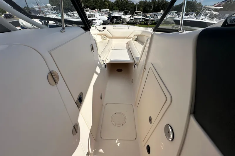 Slide: The Image of 2016 Grady-White Freedom 275 boat interior with seating and canopy under clear blue sky. - 85