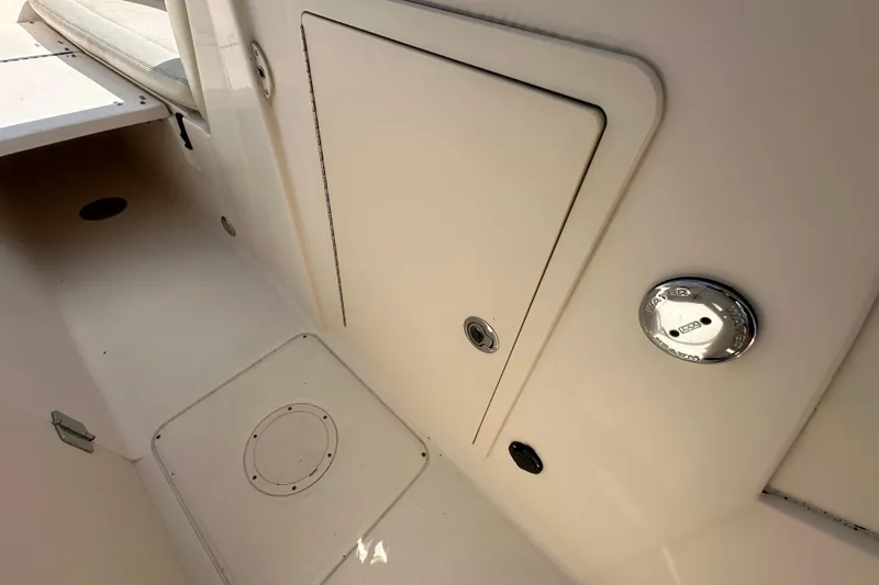 Slide: The Image of 2016 Grady-White Freedom 275 boat interior with white seating and steering wheel. - 87