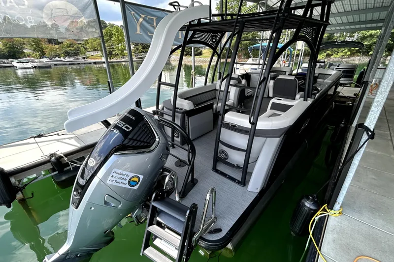 Slide: The Image of 2025 Godfrey AquaPatio 255 SDC Slide pontoon boat on a serene lake. - 16