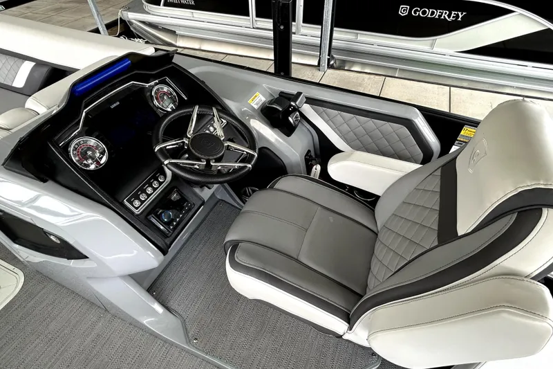 Slide: The Image of 2025 Godfrey AquaPatio 255 SDC Slide boat dashboard with steering wheel and controls. - 18
