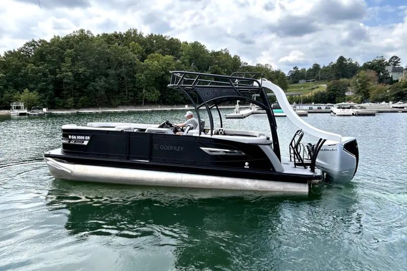 Slide: The Image of 2025 Godfrey AquaPatio 255 SDC Slide pontoon boat with slide and Honda engine on a lake. - 6