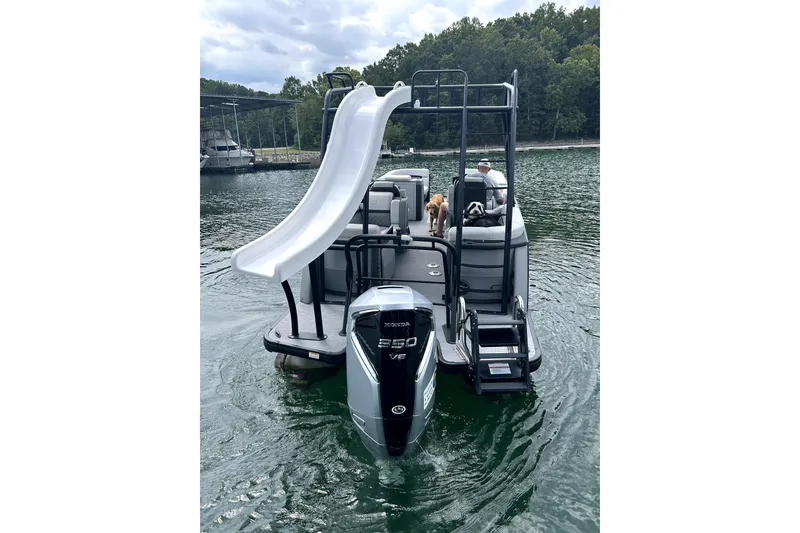 Slide: The Image of 2025 Godfrey AquaPatio 255 SDC Slide pontoon boat docked, featuring luxurious seating and sleek design. - 7