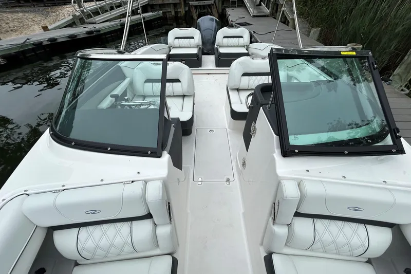 Slide: The Image of 2022 Regal LX4 boat interior with white seating and dual windshields at a dock. - 15
