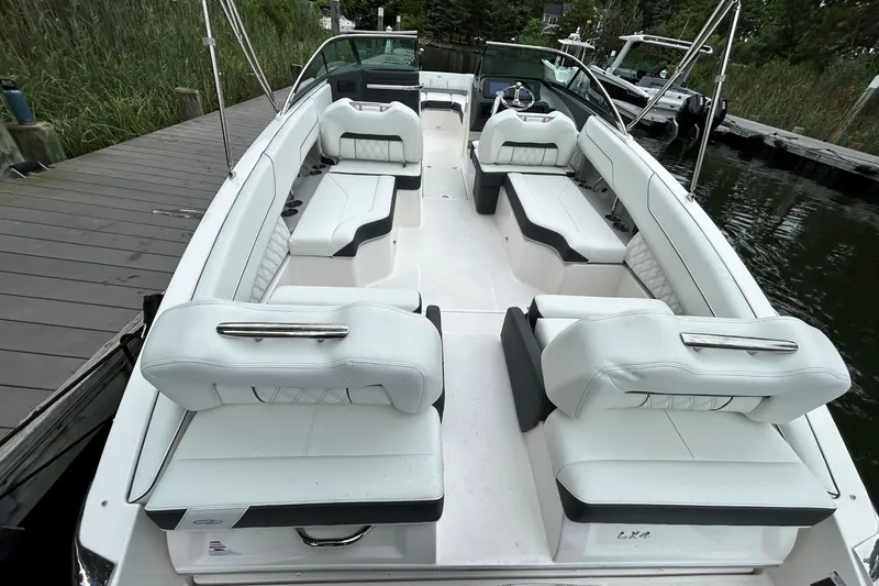 Slide: The Image of 2022 Regal LX4 boat interior with white seating, docked by a wooden pier. - 3