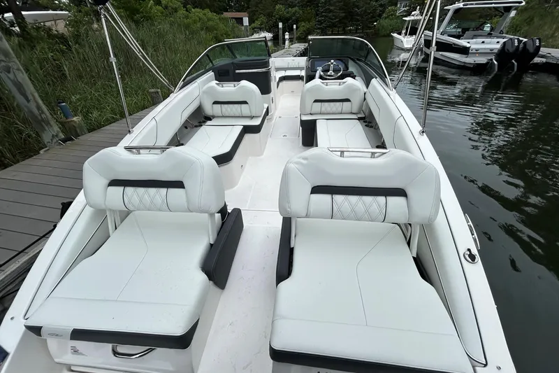 Slide: The Image of 2022 Regal LX4 boat with white seating, docked by the water. - 5