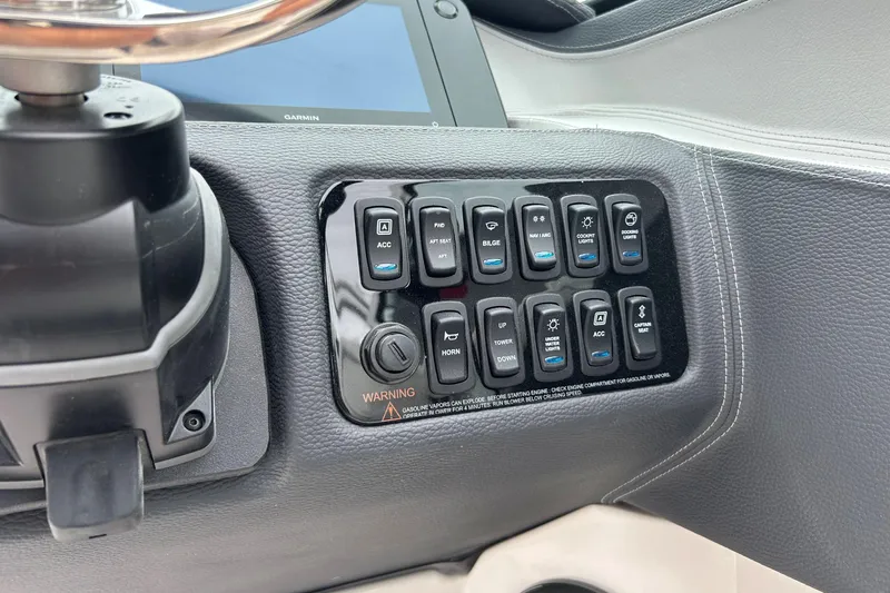 Slide: The Image of Control panel of 2022 Regal LX4 boat with various switches and buttons. - 13