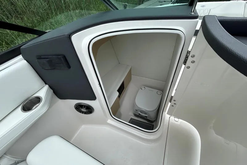 Slide: The Image of 2022 Regal LX4 boat interior with compact marine toilet and storage space. - 15