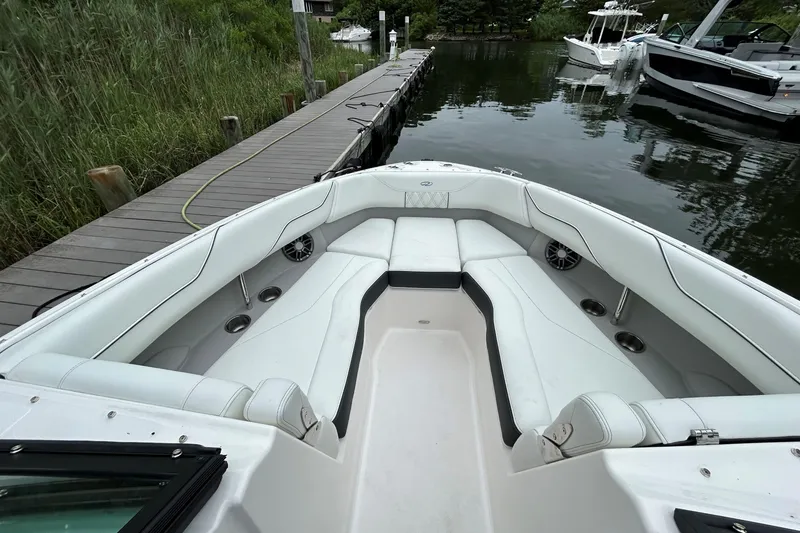 Slide: The Image of 2022 Regal LX4 boat with spacious white seating, docked by a wooden pier. - 16