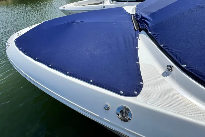 Slide: The Image of 2023 Regal LX4 boat with blue cover on water. - 20