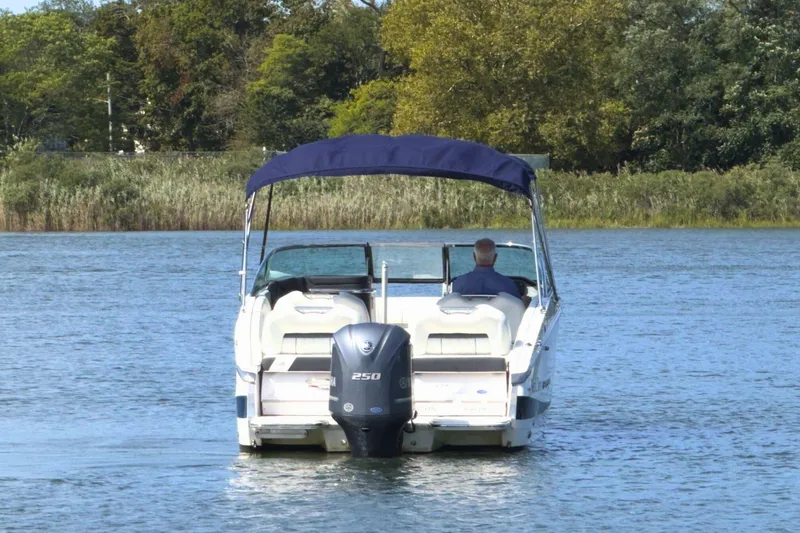 Slide: The Image of 2023 Regal LX4 boat cruising on a serene lake with lush greenery. - 7