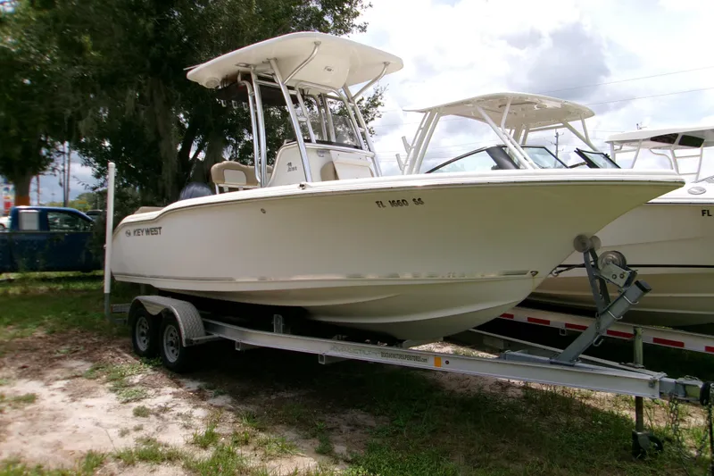 The Image of 2020 Key West 219 FS boat on trailer, parked outdoors under cloudy sky. - 0