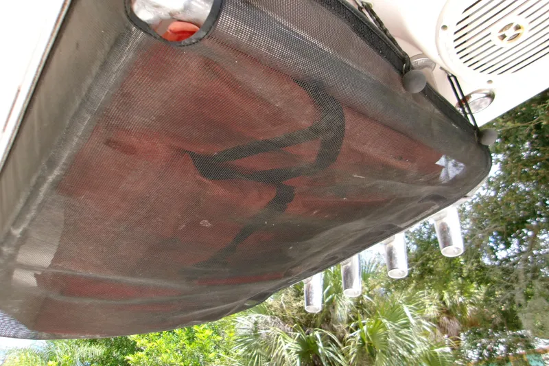 Slide: The Image of 2020 Key West 219 FS boat with mesh storage and rod holders, outdoor setting. - 19