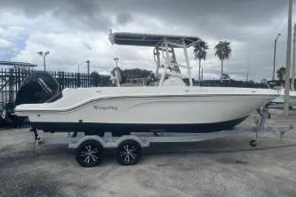 Slide: The Image of 2023 Bayliner Trophy T22CC boat on trailer, parked outdoors under cloudy sky. - 3