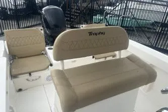 Slide: The Image of 2023 Bayliner Trophy T22CC boat interior with beige seating and motor. - 7