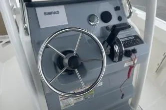 Slide: The Image of 2023 Bayliner Trophy T22CC boat dashboard with steering wheel and controls. - 8