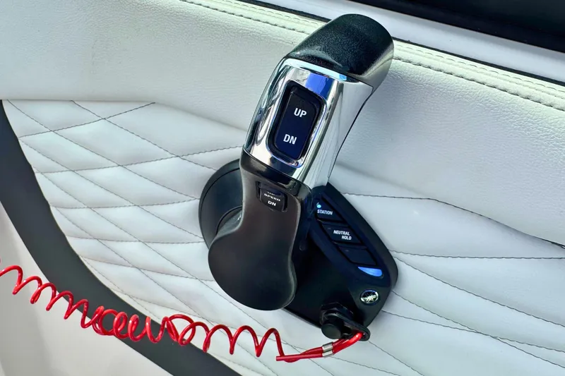 Slide: The Image of Throttle control of 2022 Regal 23 OBX boat on quilted white upholstery. - 15