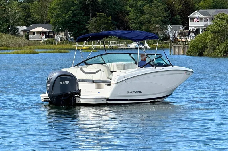 Slide: The Image of 2022 Regal 23 OBX boat with Yamaha engine on a serene lake. - 2