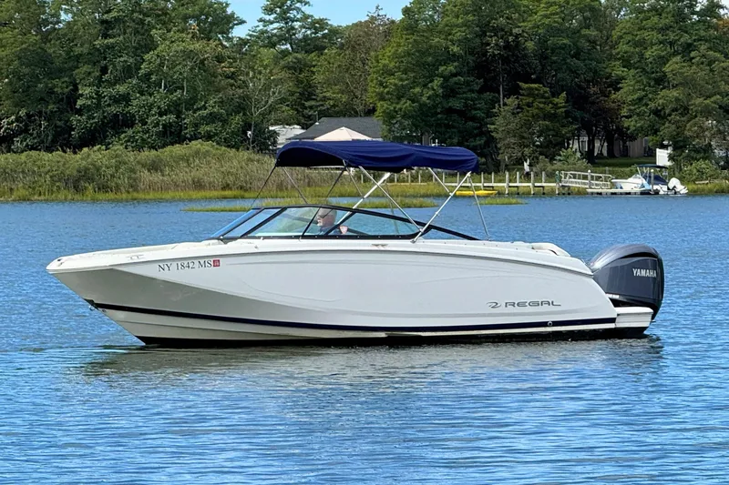 Slide: The Image of 2022 Regal 23 OBX boat with Yamaha engine on a serene lake. - 4