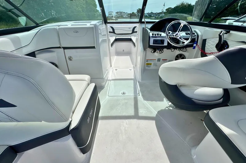 Slide: The Image of Interior of a 2022 Regal 23 OBX boat, featuring sleek seating and modern controls. - 8
