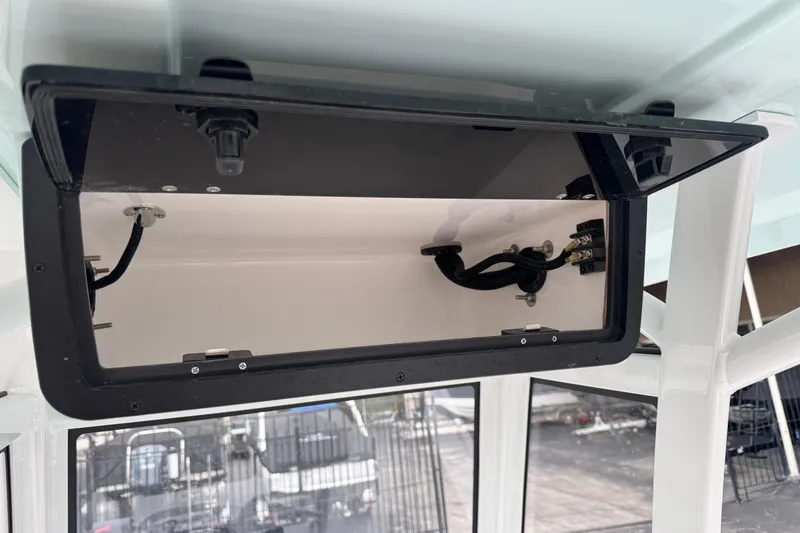 Slide: The Image of 2026 Blazer Bay 2440 boat storage compartment with wiring and secure latch. - 18