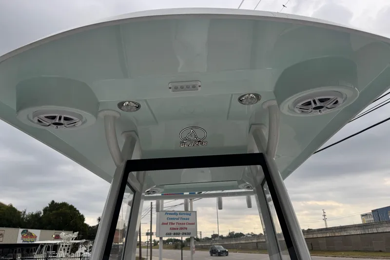 Slide: The Image of 2026 Blazer Bay 2440 boat canopy with speakers and logo, overcast sky background. - 19