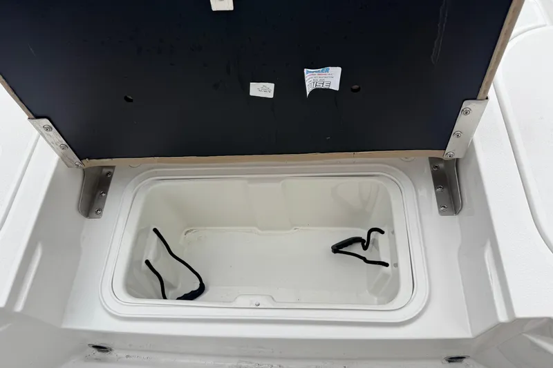 Slide: The Image of Open storage compartment in 2026 Blazer Bay 2440 boat, featuring metal hinges and interior space. - 24