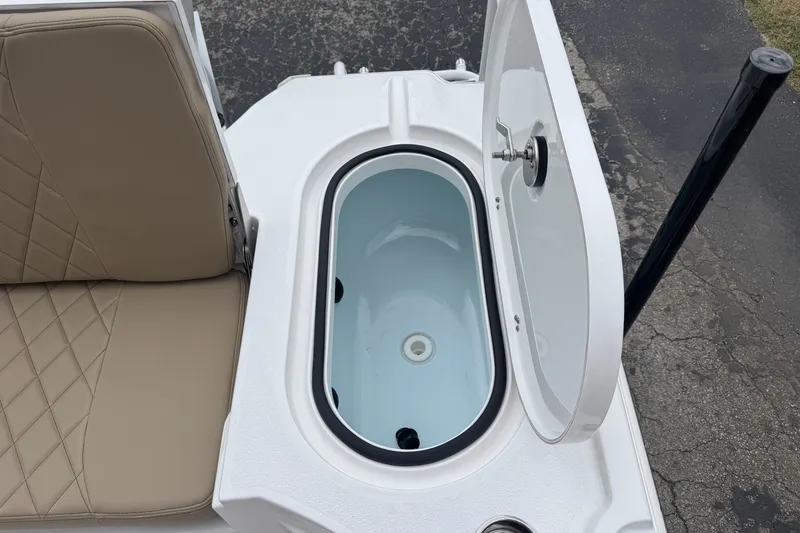 Slide: The Image of 2026 Blazer Bay 2440 boat with open storage compartment and cushioned seating. - 26