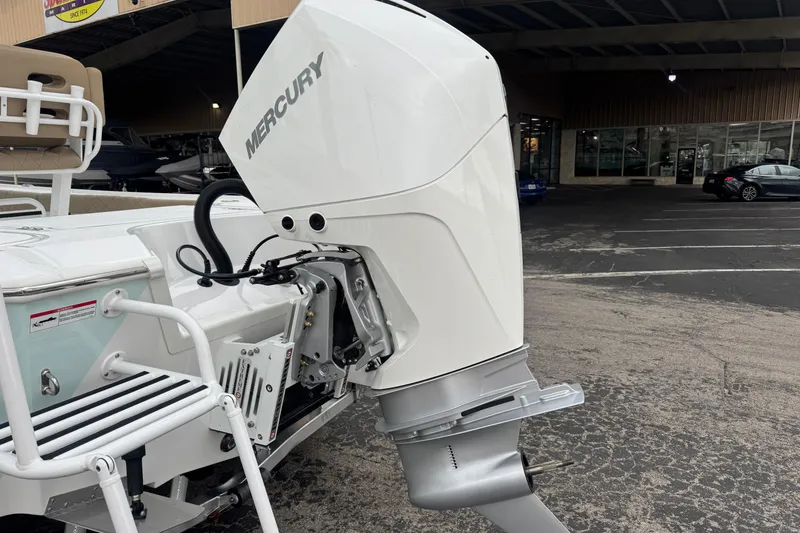 Slide: The Image of 2026 Blazer Bay 2440 boat with Mercury outboard motor in a dealership parking lot. - 4