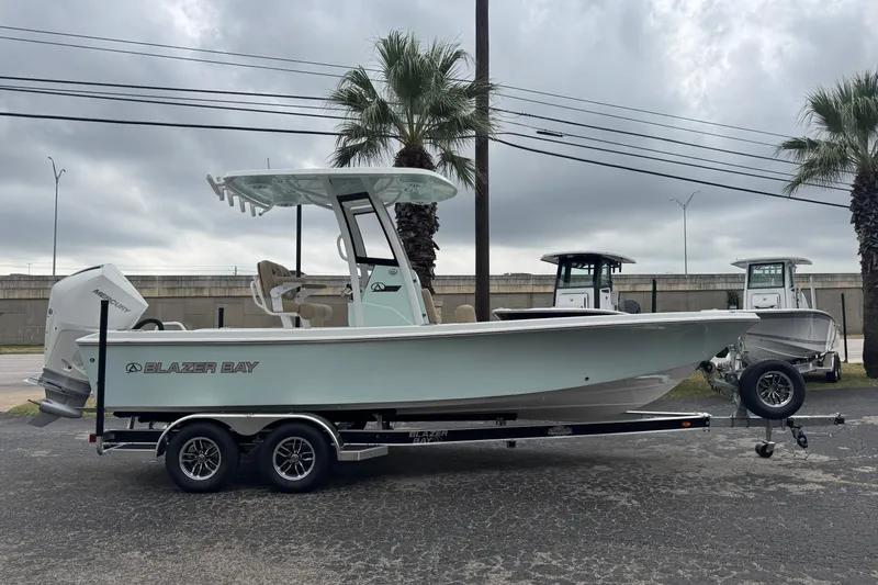 Slide: The Image of 2026 Blazer Bay 2440 boat on trailer, parked outdoors under cloudy sky. - 47