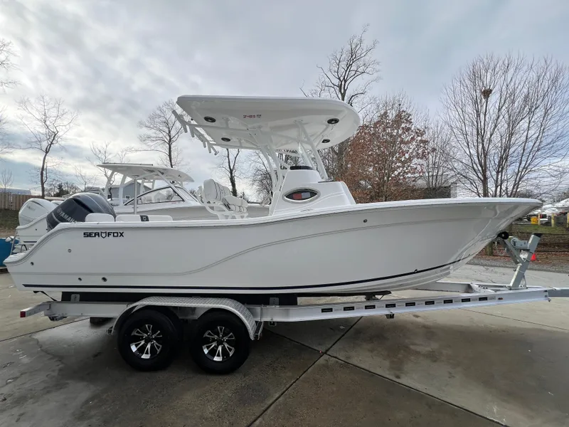 The Image of 2024 Sea Fox 248 Side Console boat on trailer, parked outdoors. - 0