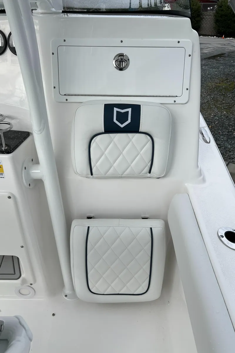 Slide: The Image of 2024 Sea Fox 248 Side Console boat interior with white cushioned seating and storage compartment. - 13