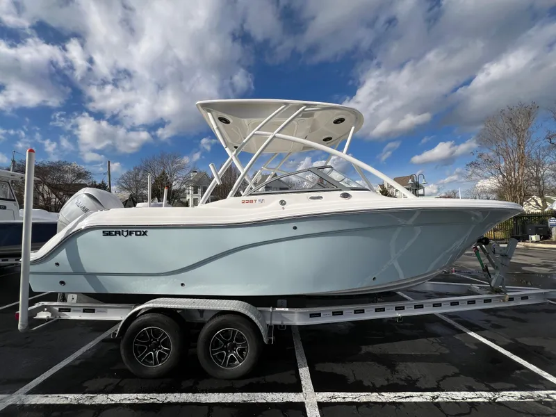 The Image of 2024 Sea Fox 228 Traveler boat on a trailer under a partly cloudy sky. - 10