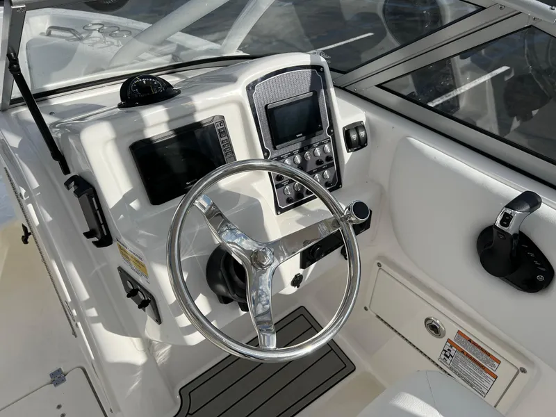 Slide: The Image of 2024 Sea Fox 228 Traveler boat dashboard with steering wheel and navigation controls. - 19