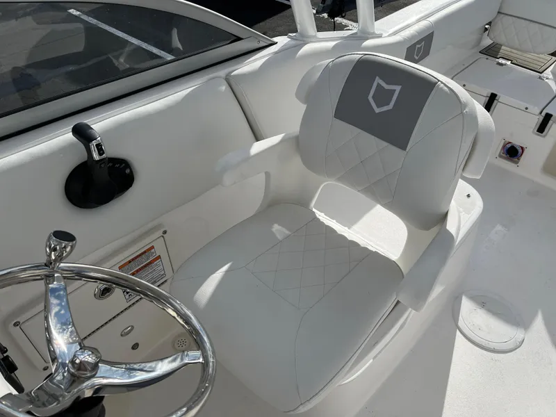 Slide: The Image of 2024 Sea Fox 228 Traveler boat interior with white captain's chair and steering wheel. - 20