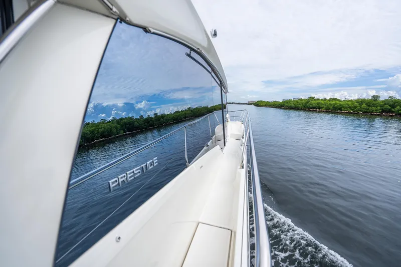 Slide: The Image of 2018 Prestige 520S yacht cruising on a serene waterway with lush greenery. - 24